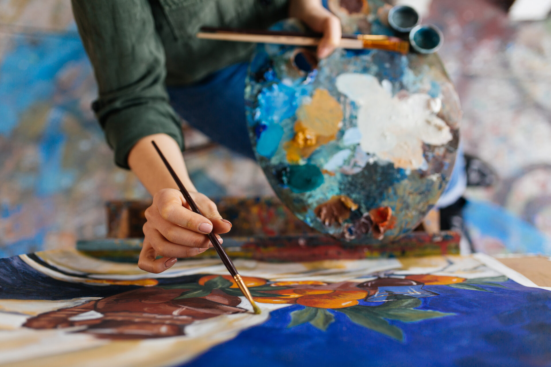 View of a woman's hands drawing a picture on canvas