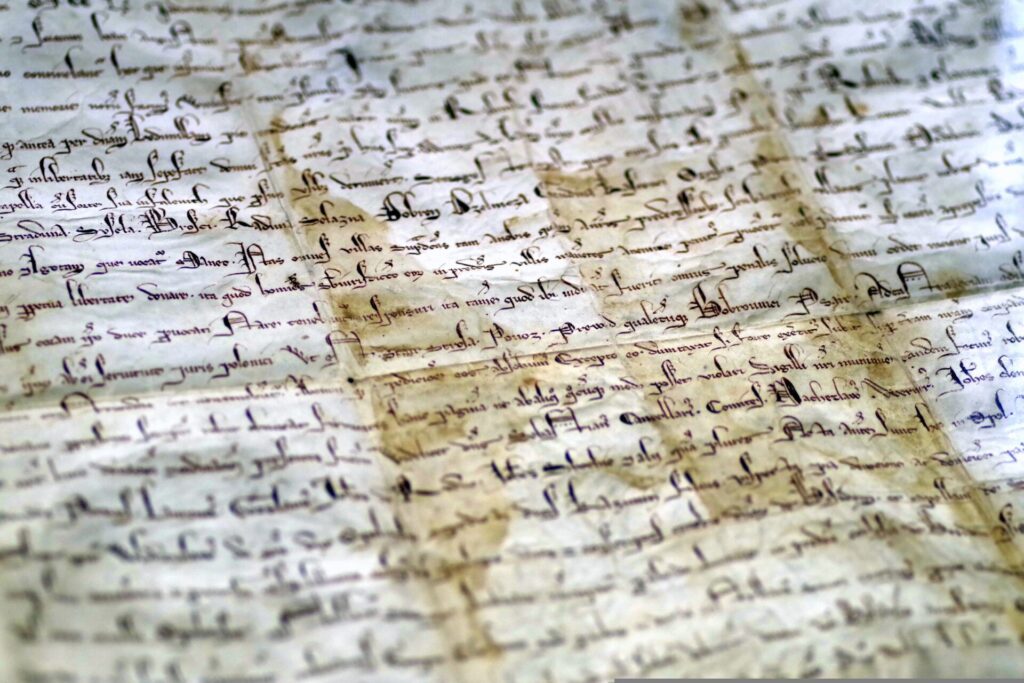 A picture of an antique parchment with handwritten ancient text