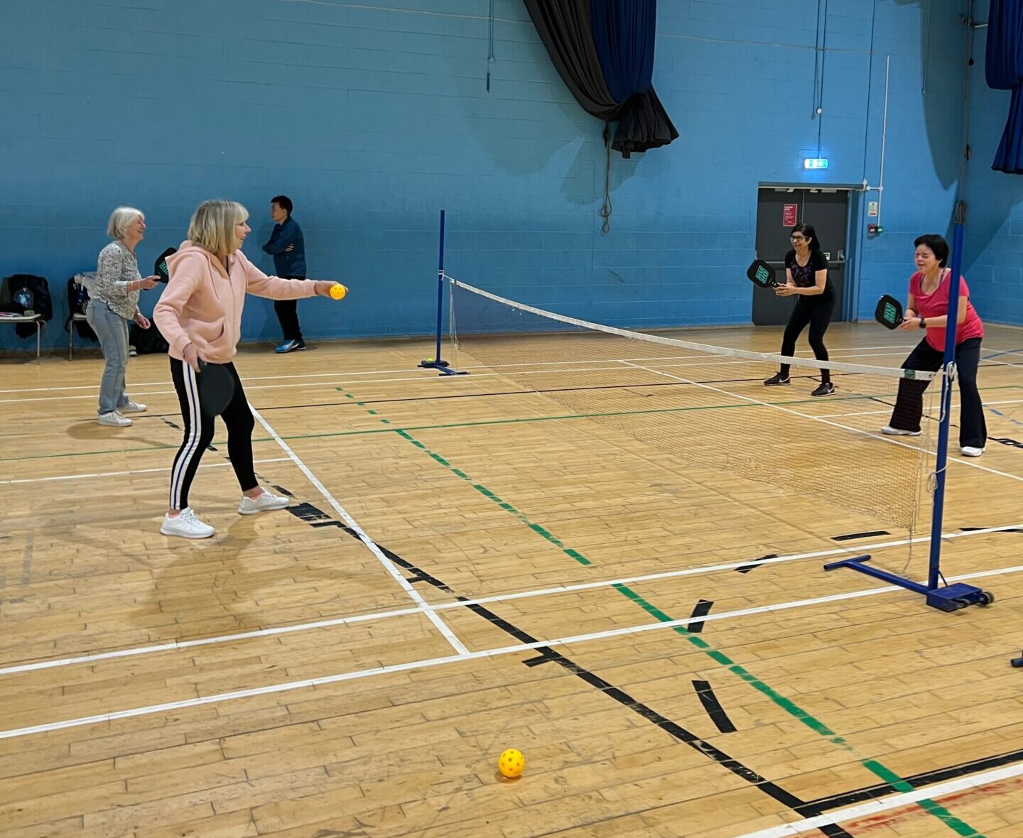 4 people playing pickleball