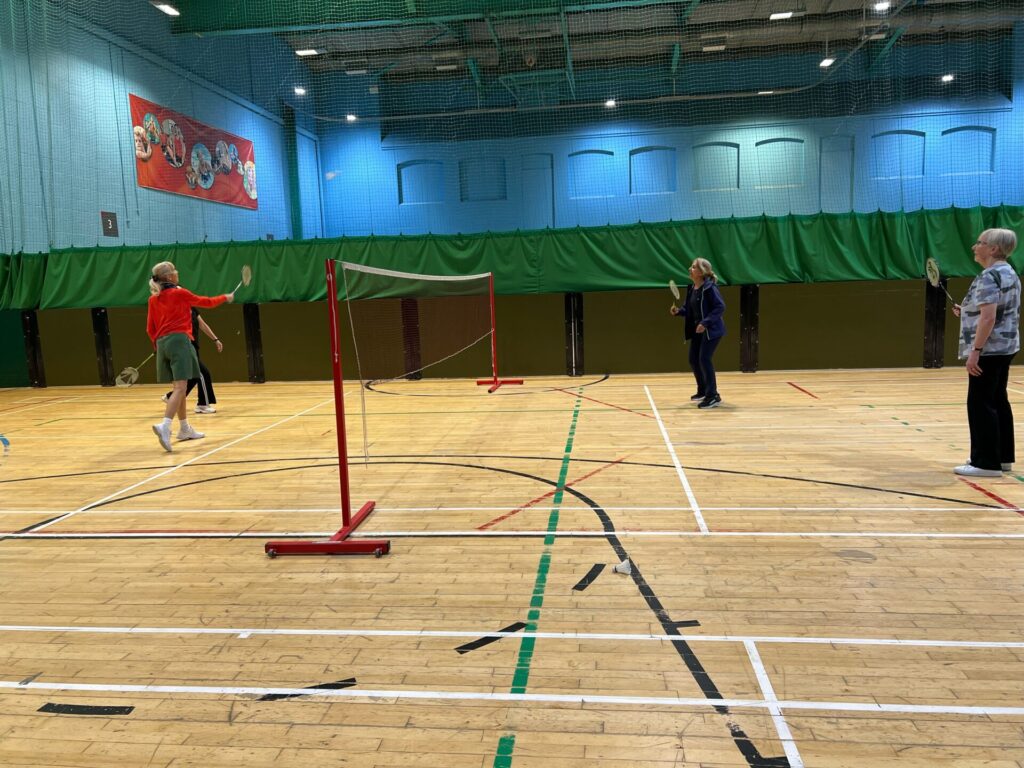 4 people playing badminton