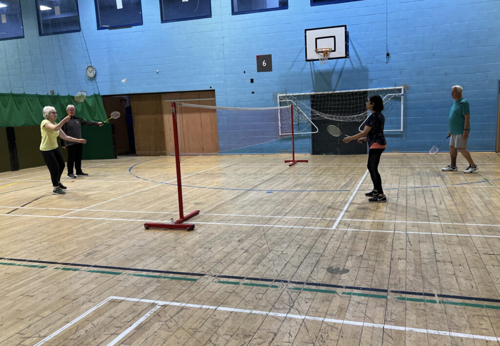 Four people playing badminton