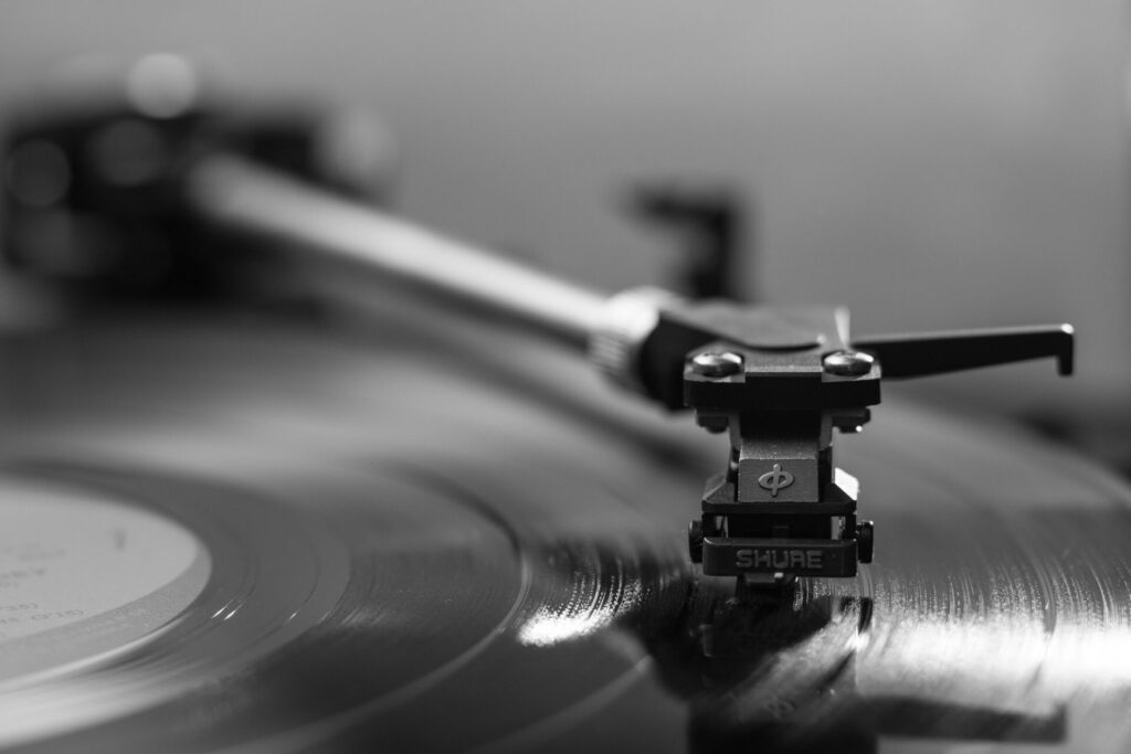 A black and white photo of a record player, playing a long-playing record